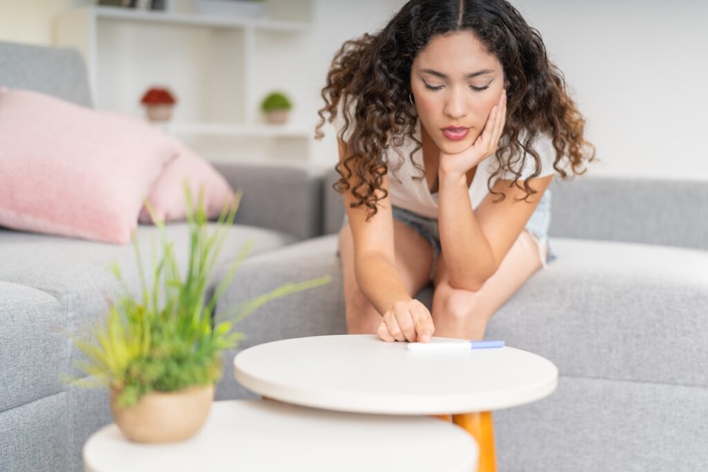 Impatient and nervous woman checking a pregnancy test to see the results